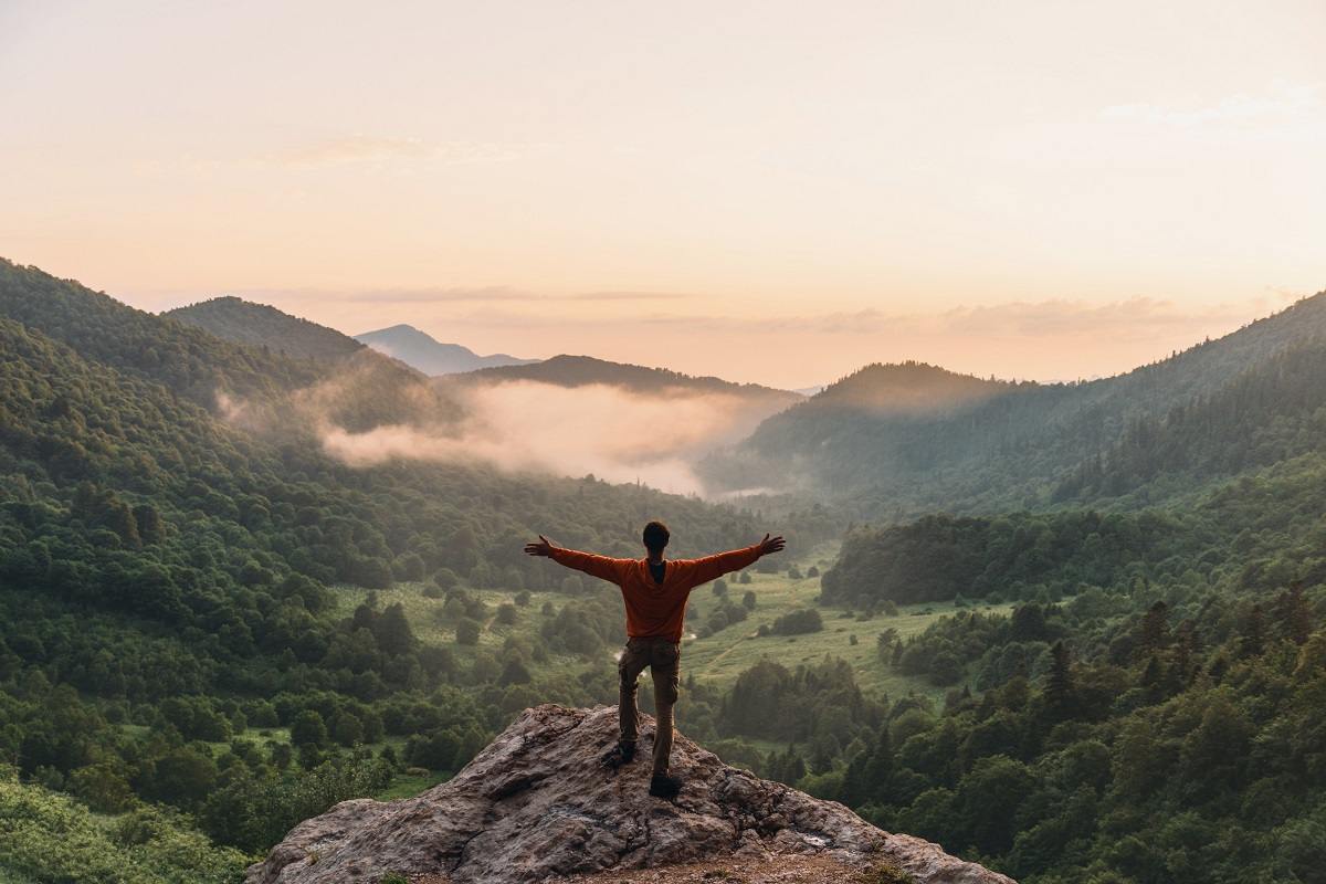 Man Standing On The Top Of The Hill